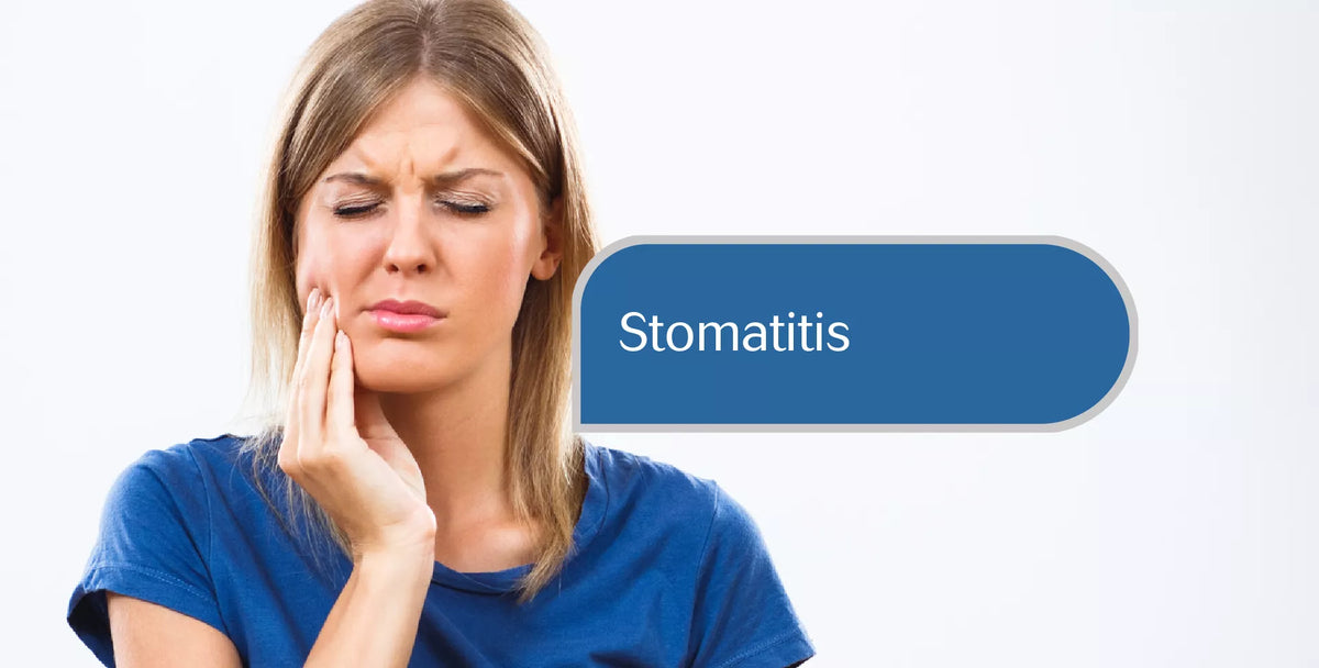 A woman with a distressed expression holds her cheek, with a blue label overlay reading 'Stomatitis' on a plain white background.